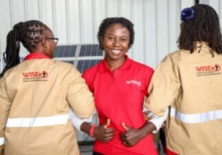 WISEe members smiling and showing their uniforms.